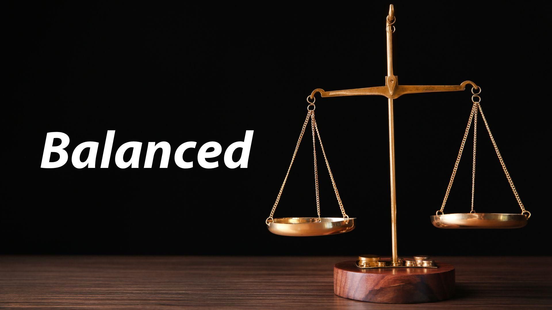 A scale of justice is sitting on a wooden table.