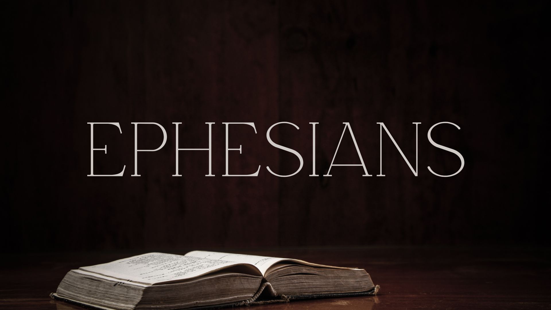 An open bible is sitting on a wooden table.
