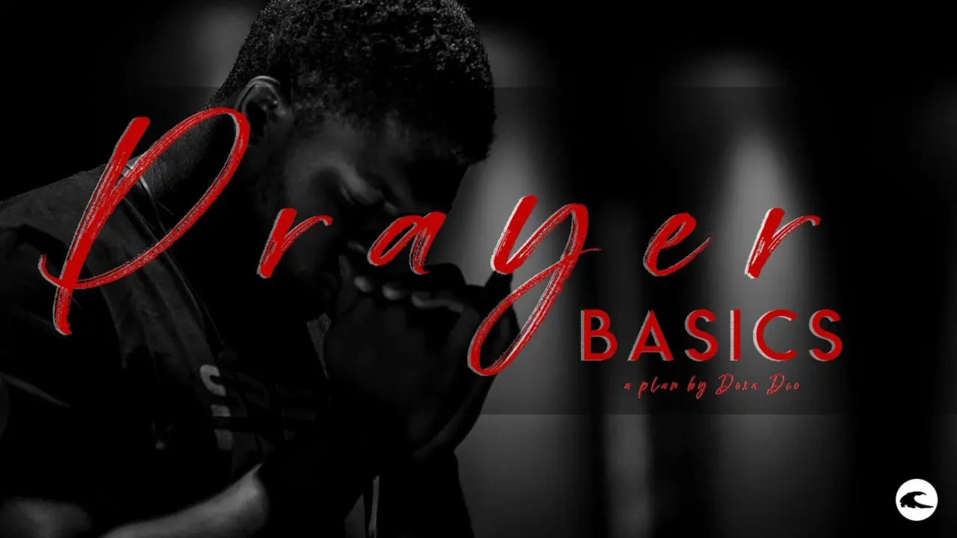 A man is praying with his hands folded in front of a sign that says prayer basics