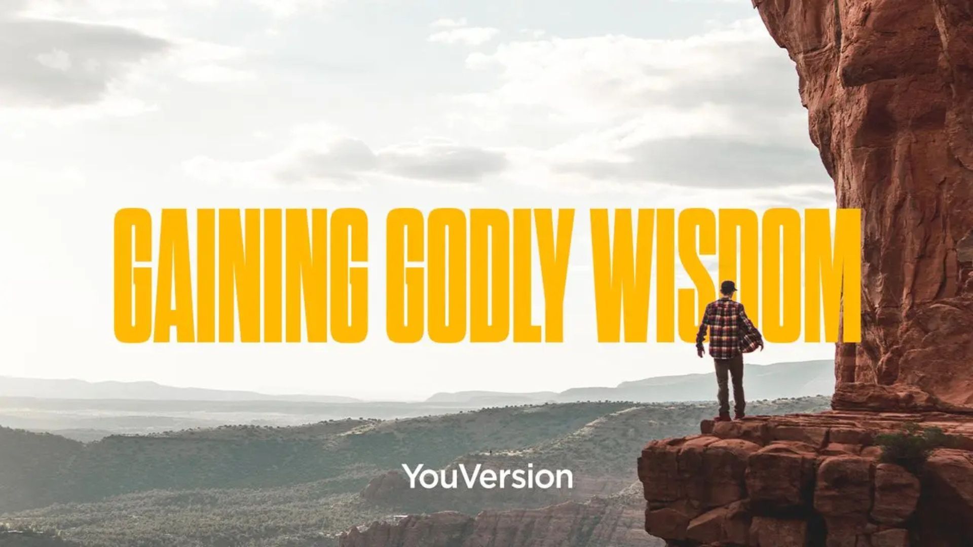 A man is standing on the edge of a cliff.