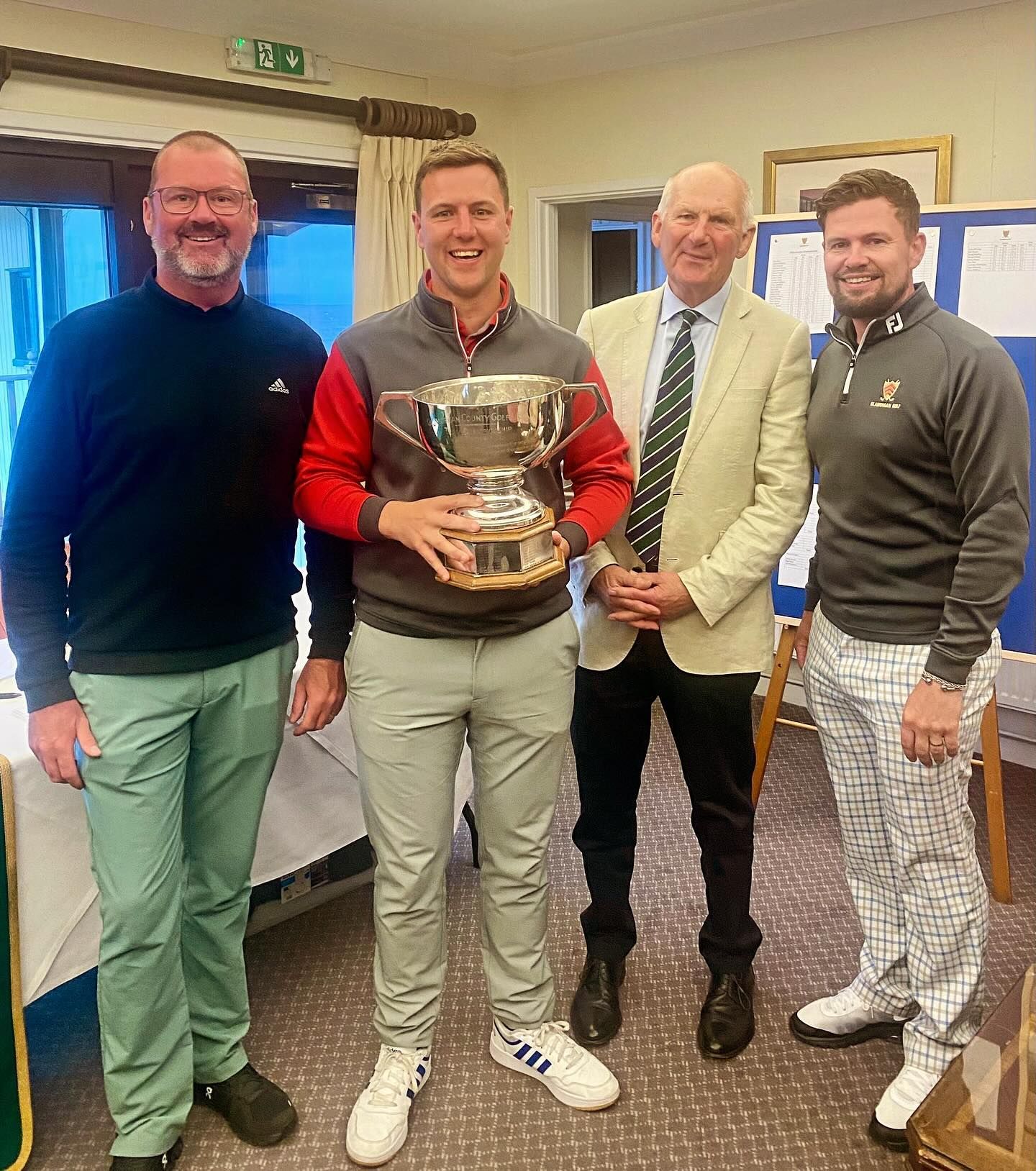 A group of men standing next to each other holding a trophy