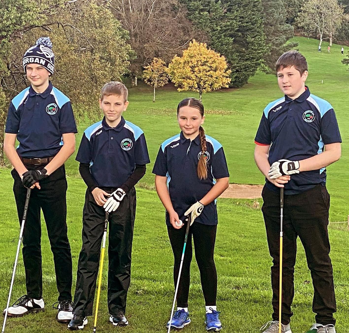 A group of young people are standing on a golf course holding golf clubs.