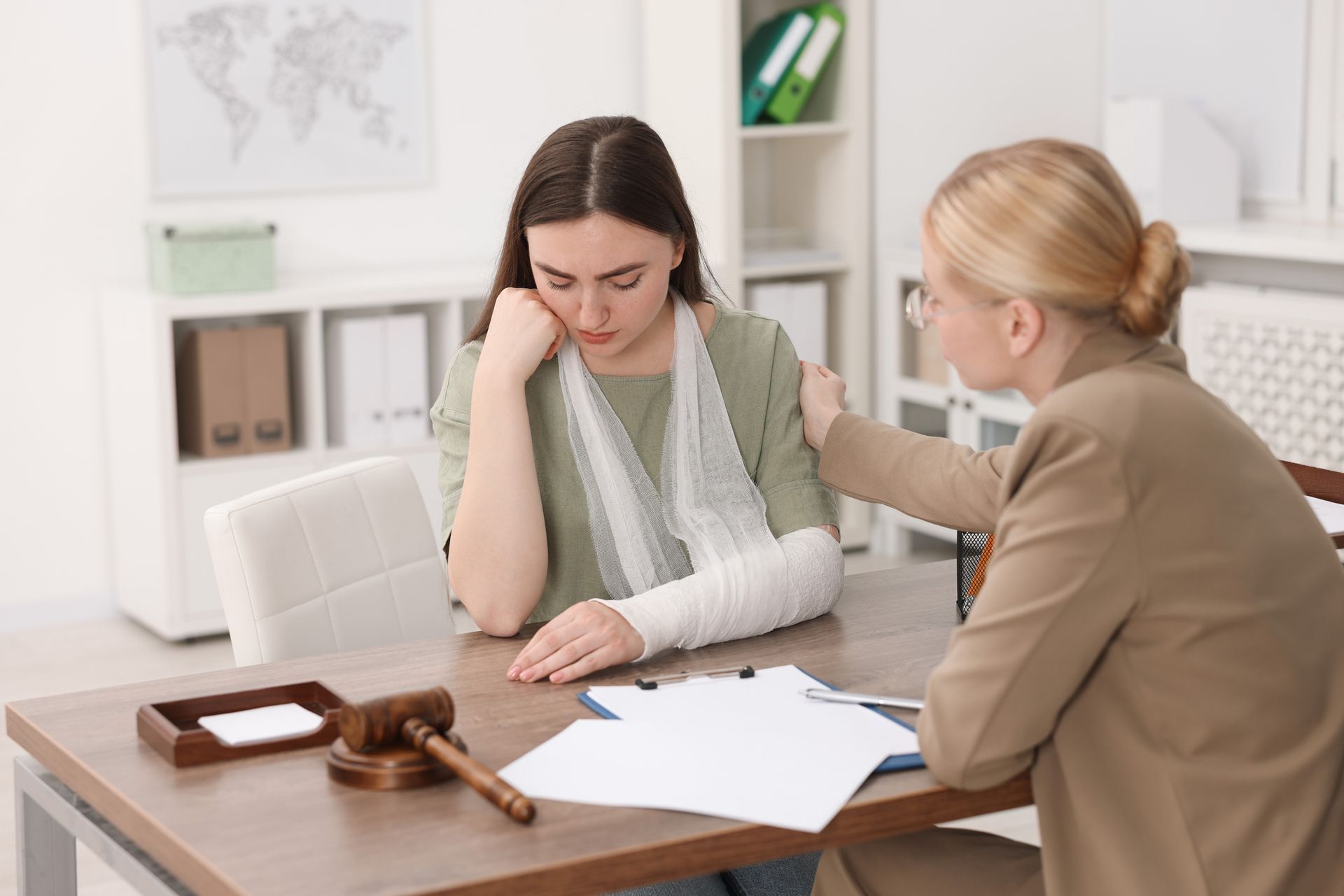An injured woman meets with a lawyer in the office for a legal consultation. An injured woman meets with a lawyer in the office for a legal consultation.