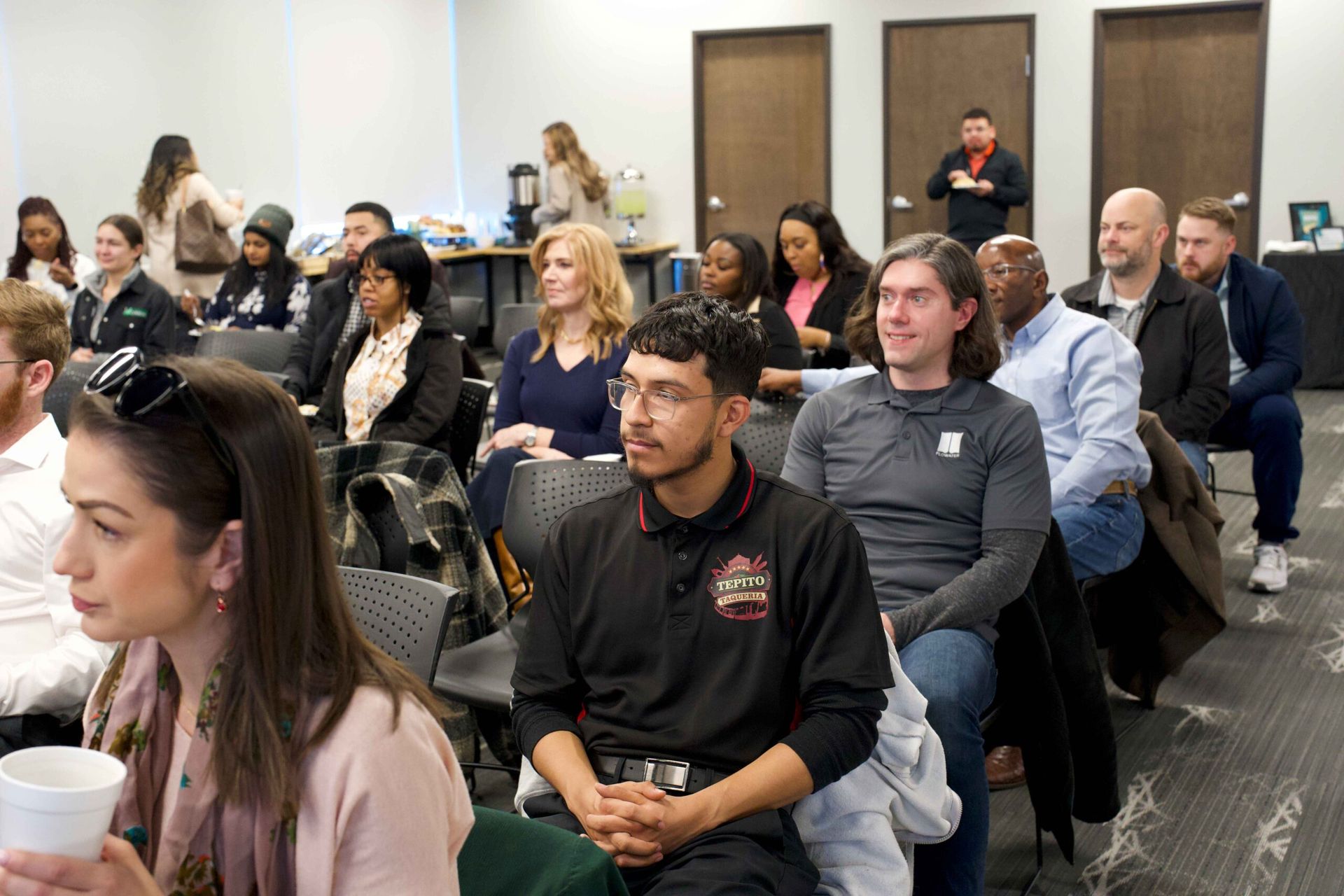 Audience seated in a conference room, listening during a presentation