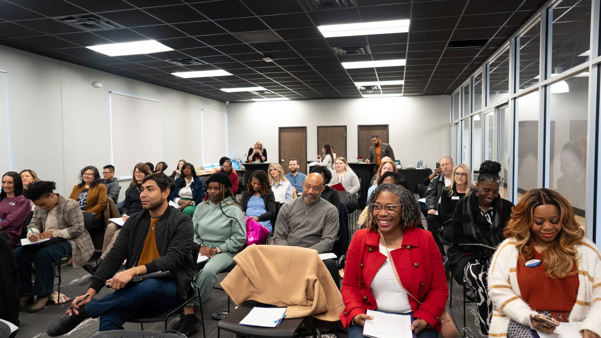 Audience seated in a conference room, listening attentively during a meeting or presentation.