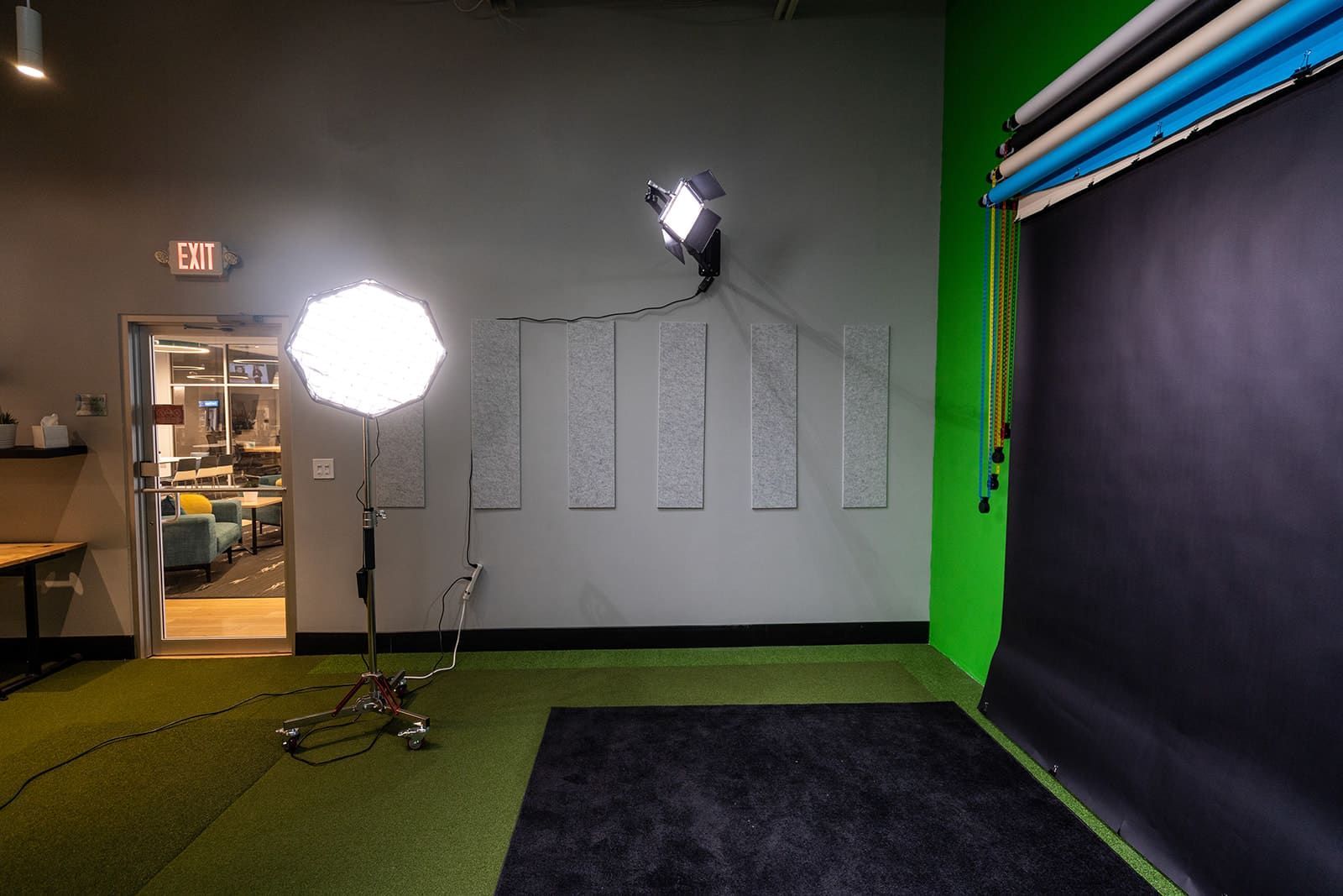 Photography studio with two lights, green wall, and dark backdrop setup