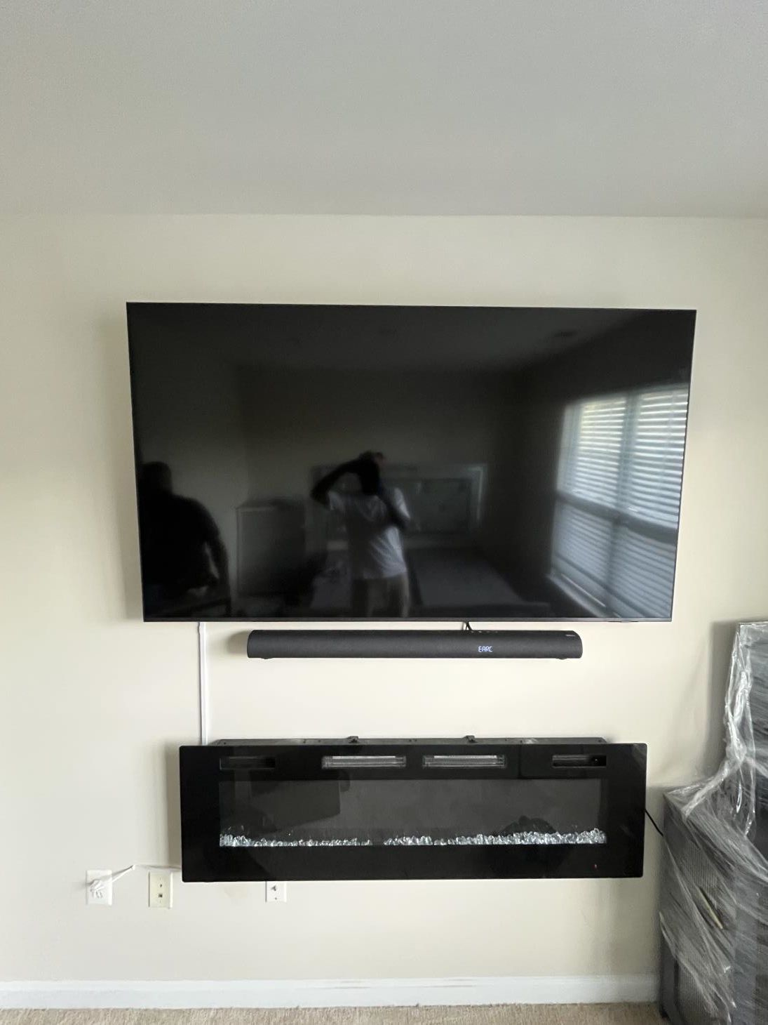 Wall-mounted flat-screen TV above a linear fireplace in a bright living room