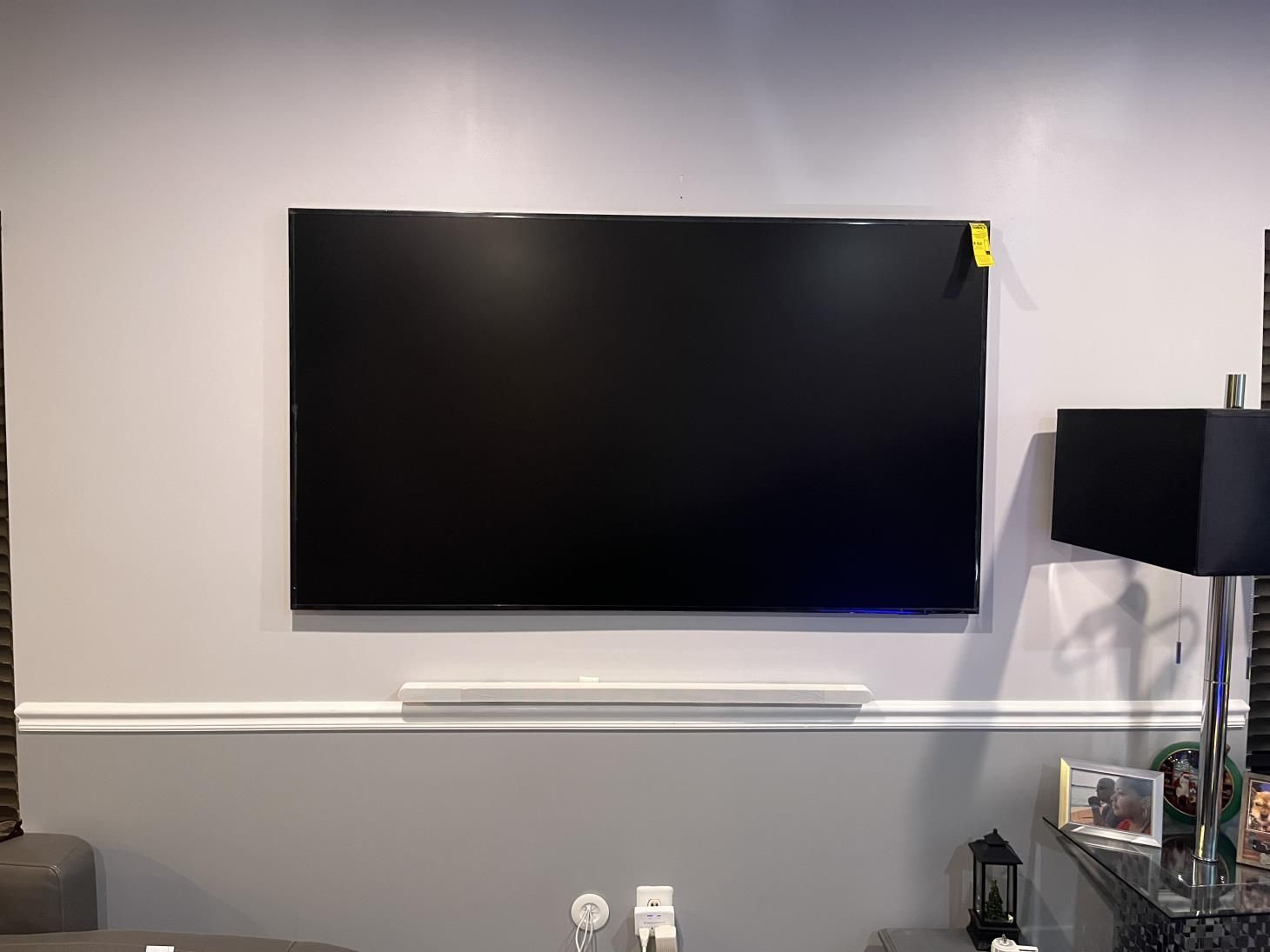 Wall-mounted flat-screen TV above a white console in a modern living room
