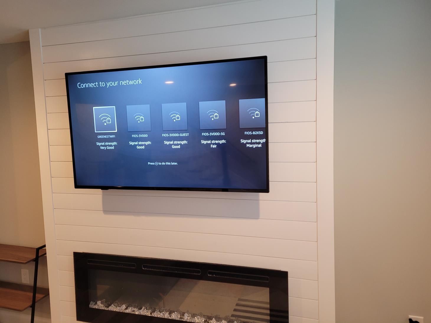 Wall-mounted TV above a white shiplap fireplace in a modern living room