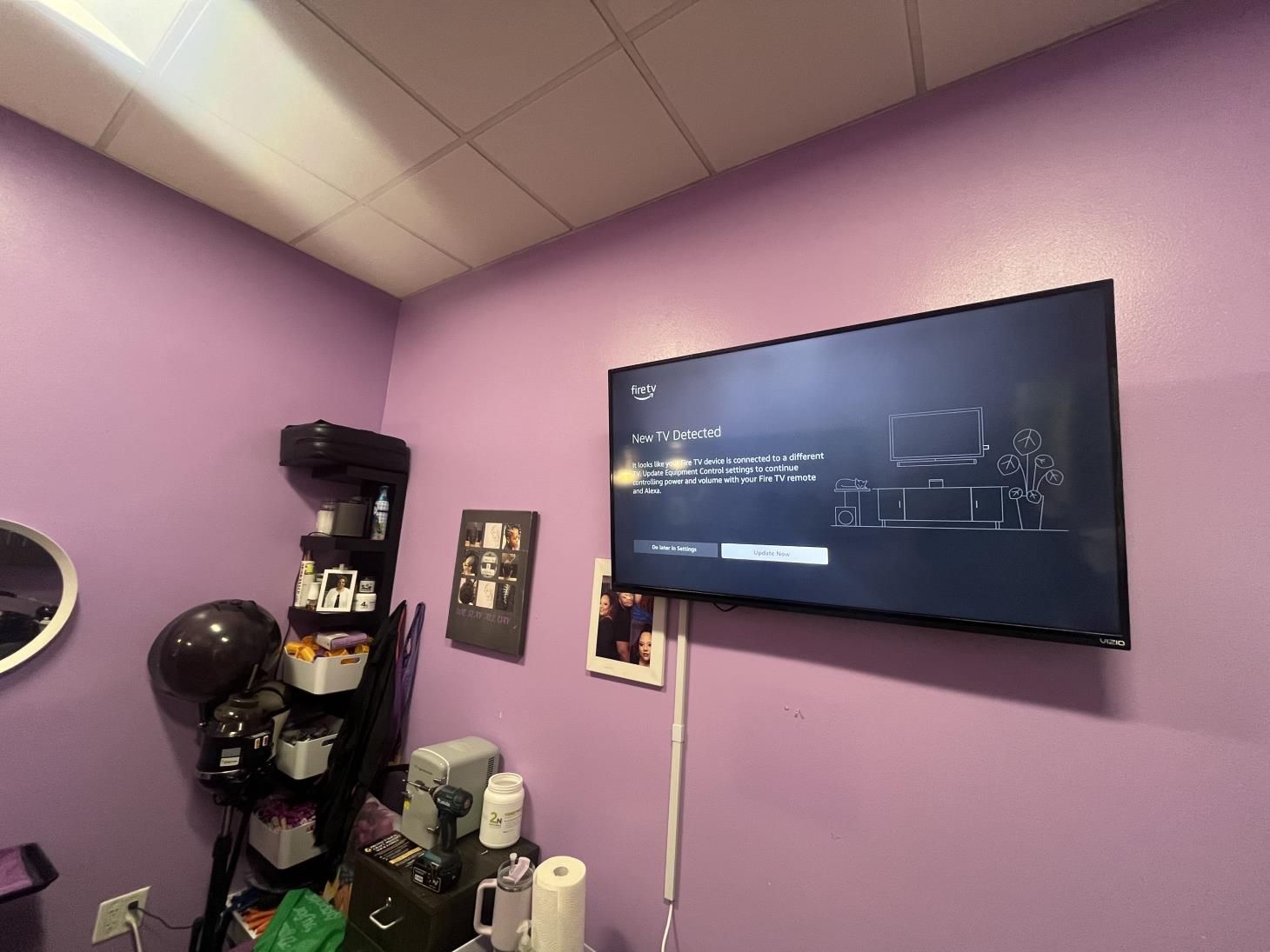 Purple room with wall-mounted TV, corner shelf, and exercise ball under a slanted ceiling.