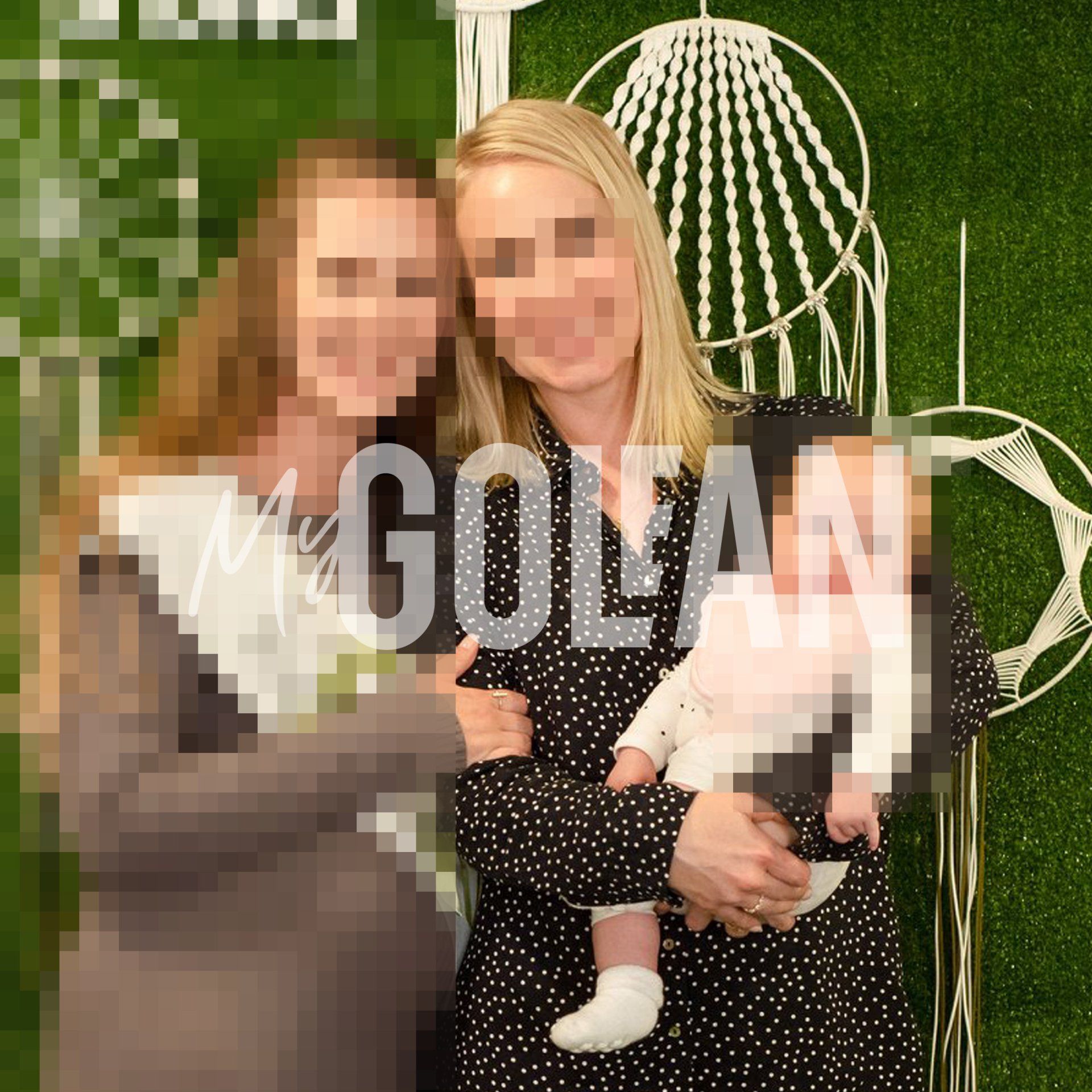 A blurry picture of two women holding a baby with the word golan on the bottom