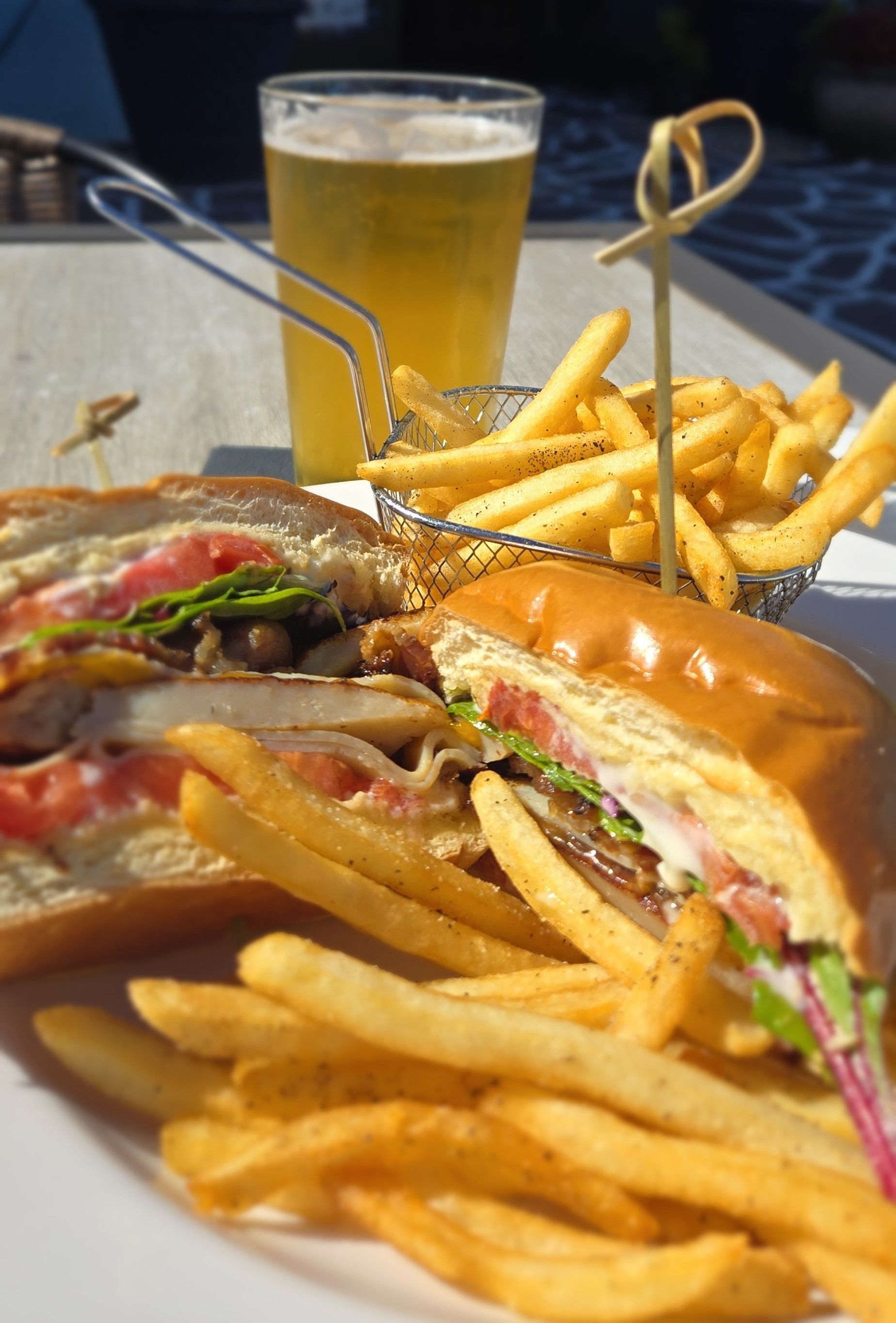 Burger and fries on a tray with a drink in the background
