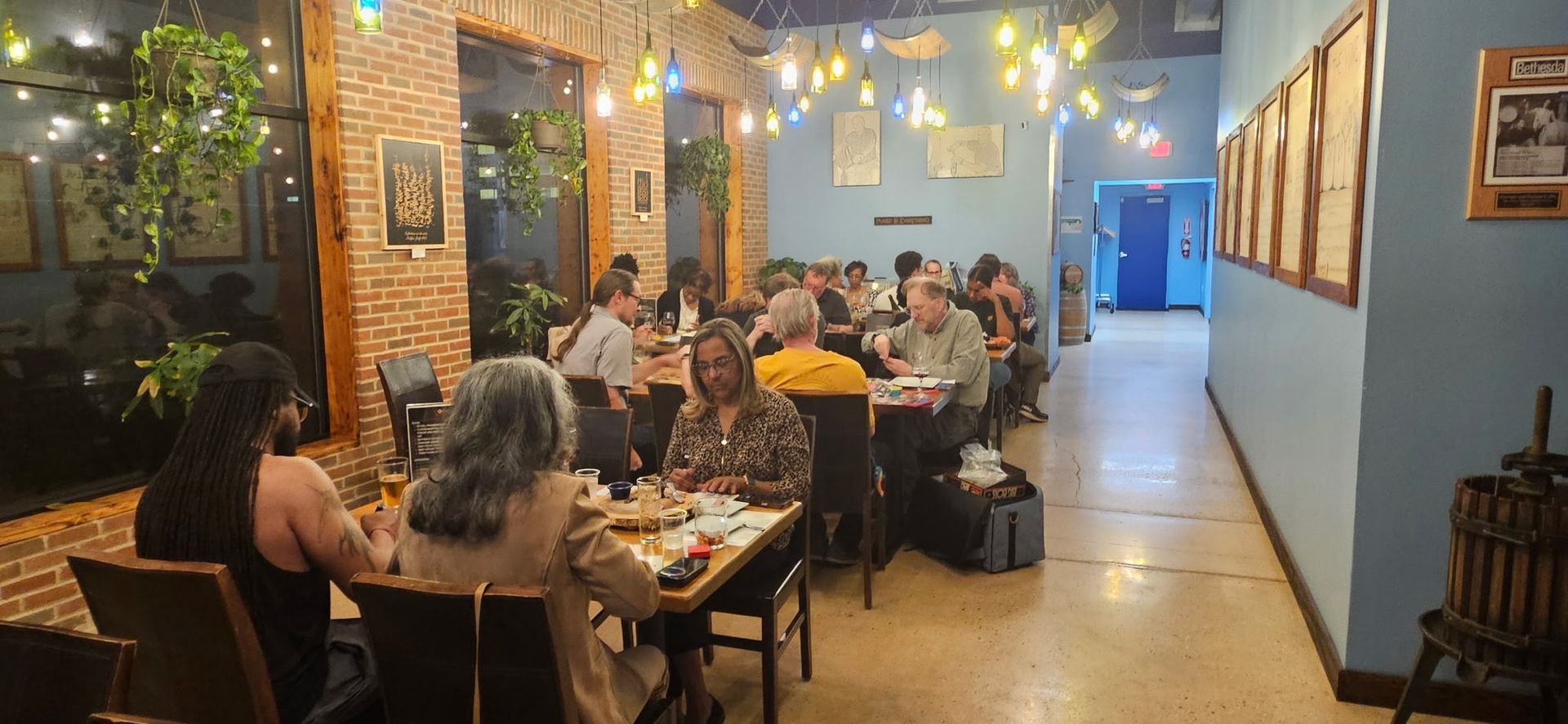 Cozy café interior with people dining at tables under warm string lights