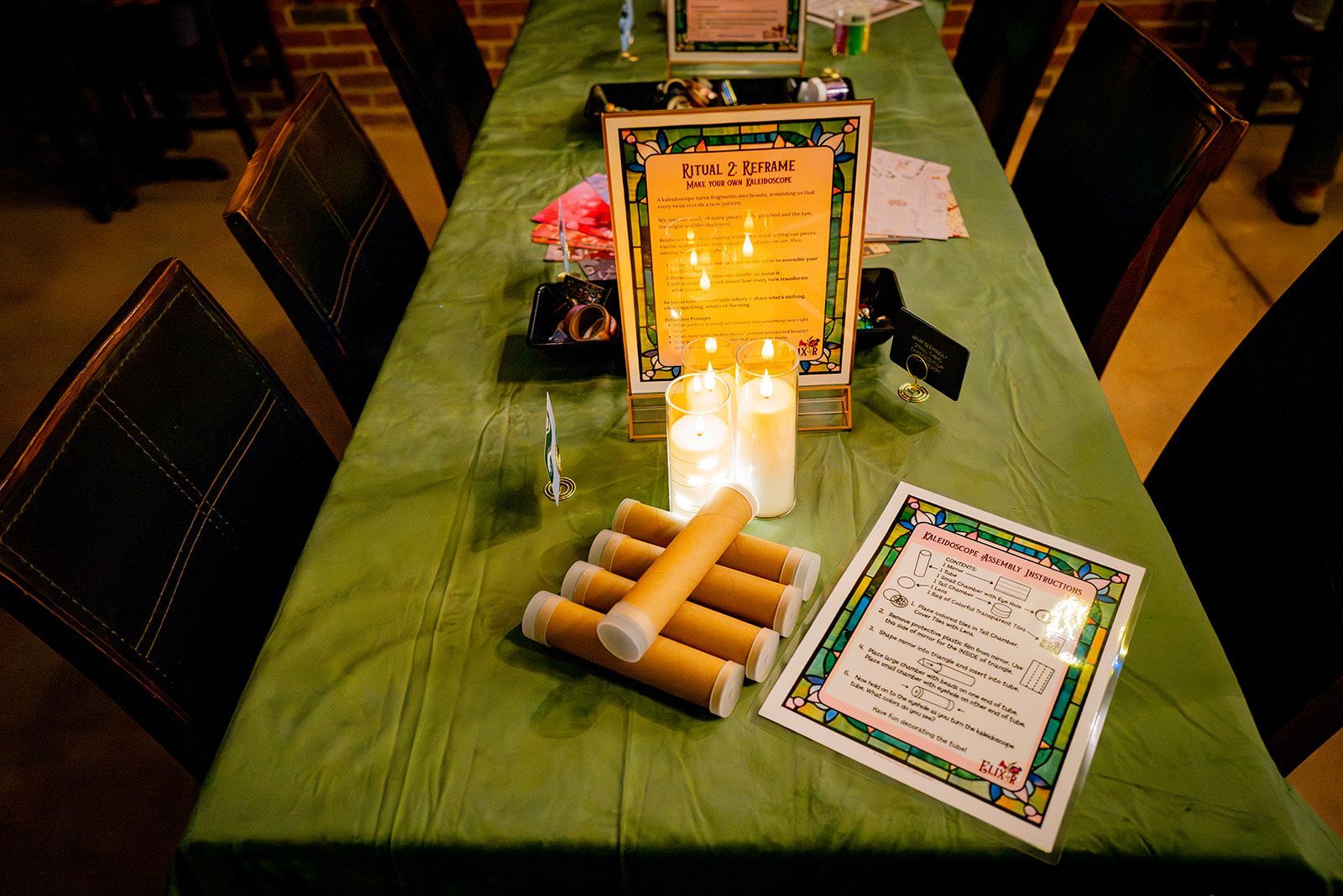 Green table with lit candles, flowers, and framed memorial messages in a church aisle