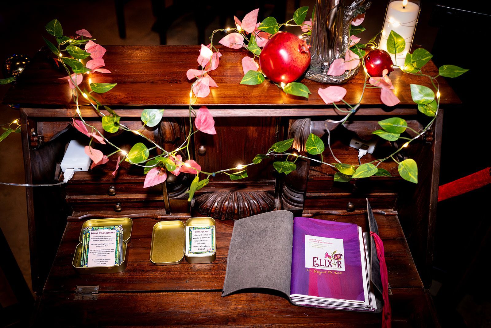 Decorated wooden shelf with flowers, lights, and small bags or packets arranged on a table