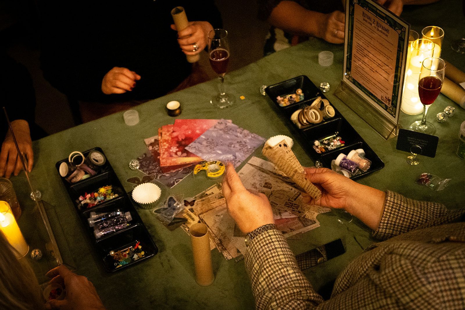 People playing cards at a green felt table with drinks and chips.
