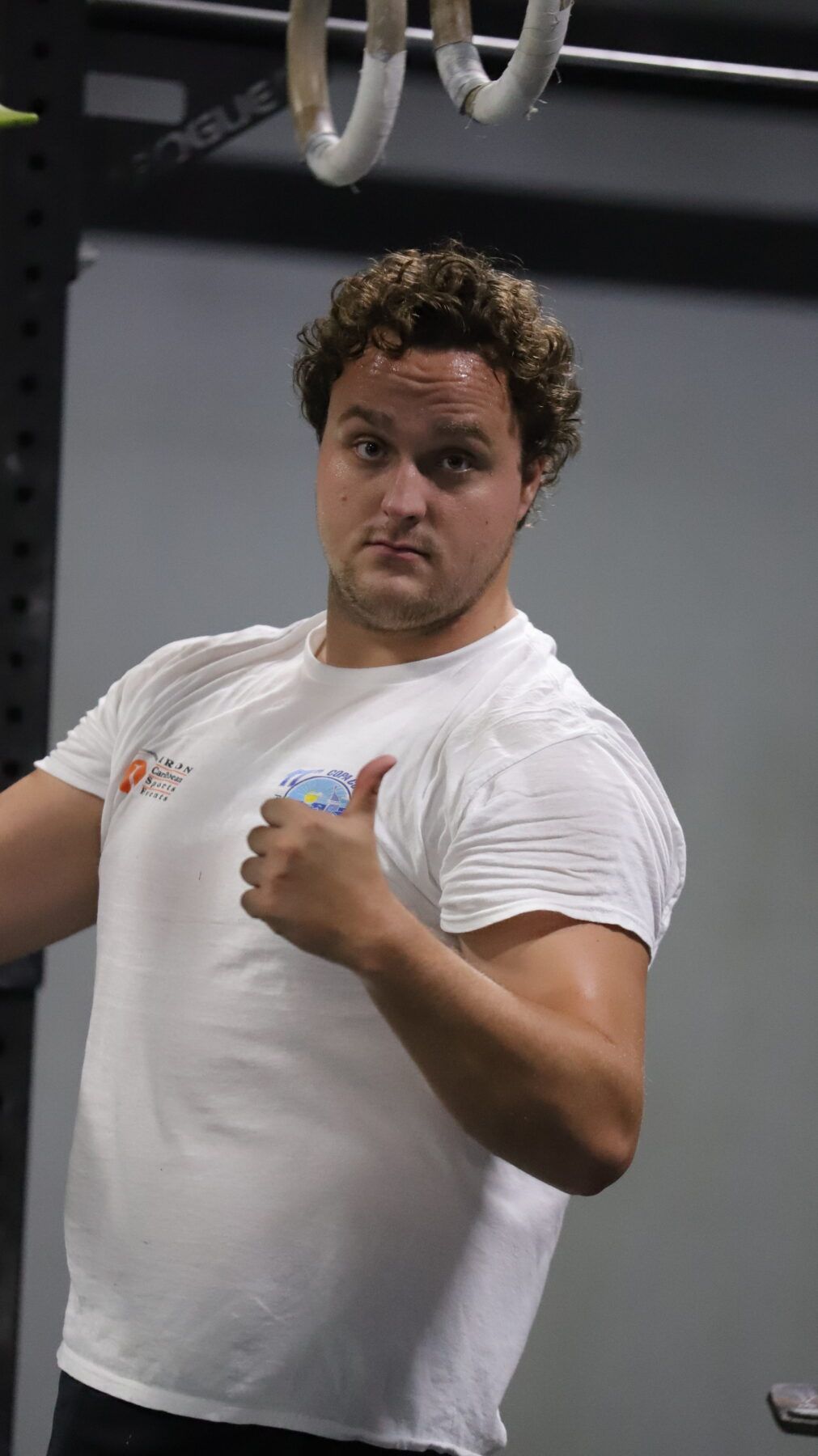 A man in a white shirt is giving a thumbs up at CrossFit Vertex gym in Olyphant, PA