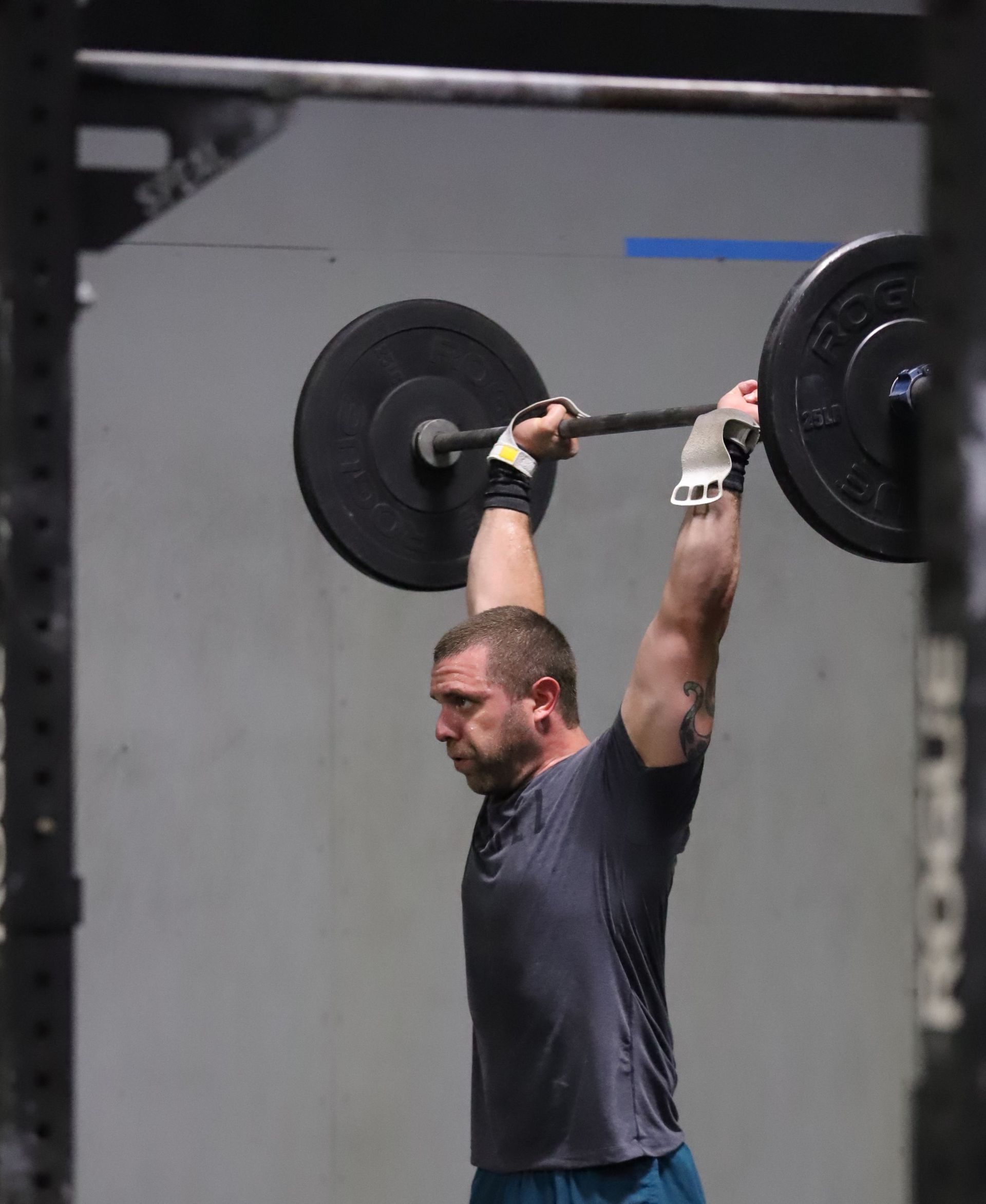 A man with a barbell overhead.