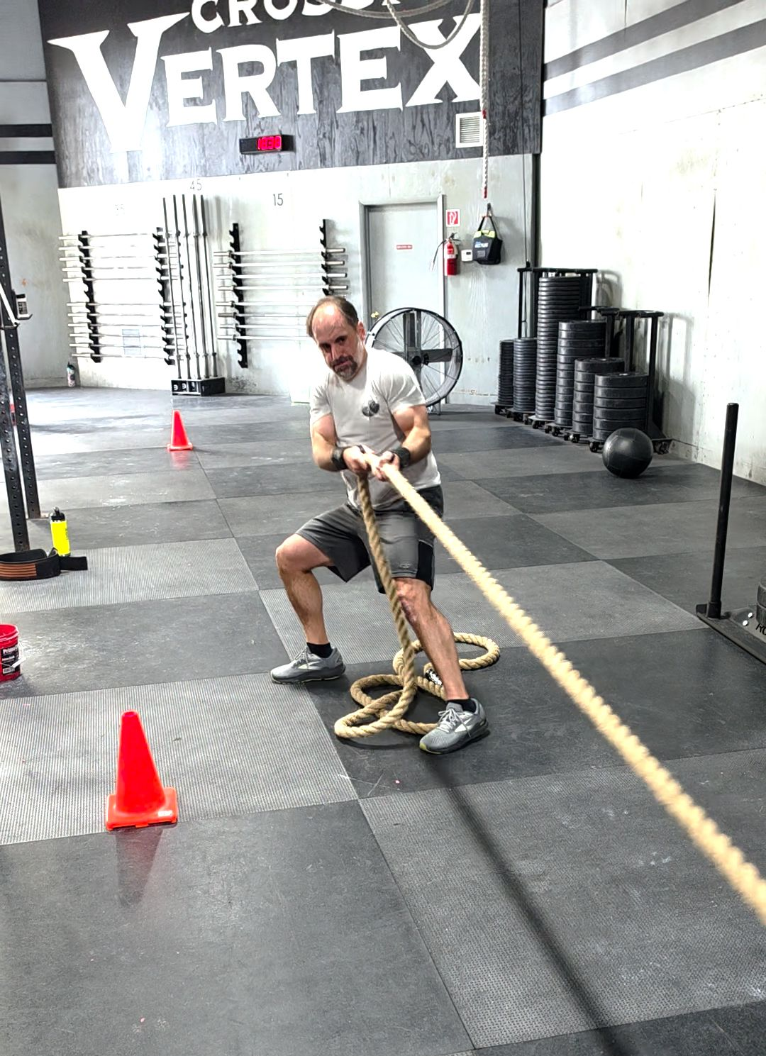 A man pulls a rope with a weighted sled attached to it.