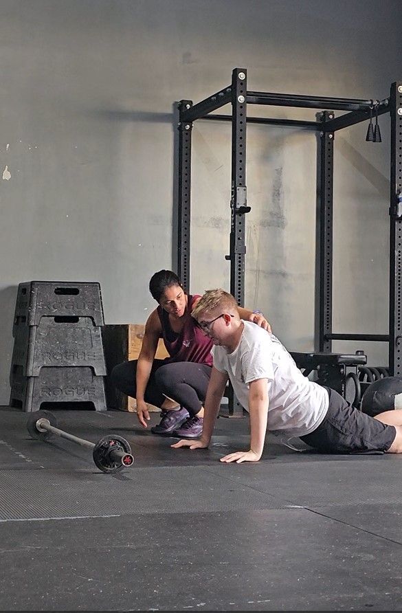 A Coach guides her athlete through the push up.