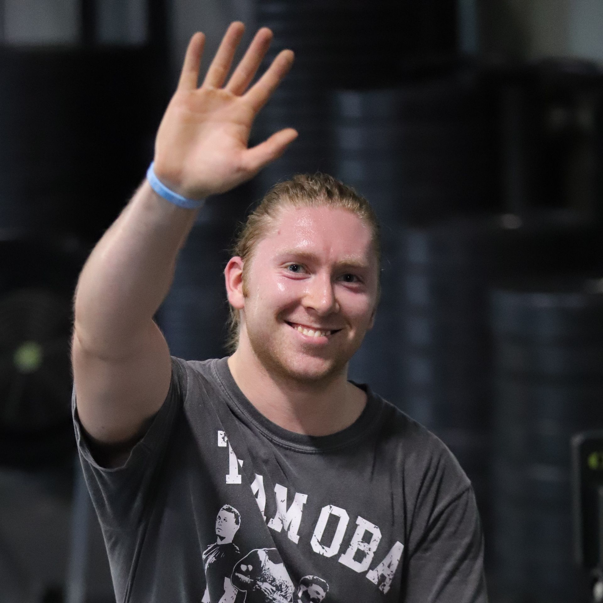A man with a big smile and a wave