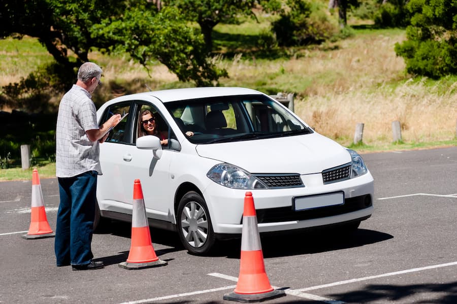 A Man is Talking to a Woman in a White Car — NT Driving Academy in Woolner, NT