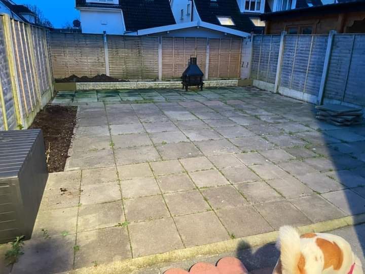 Patio with stone pavers, fire pit, and wooden fences.