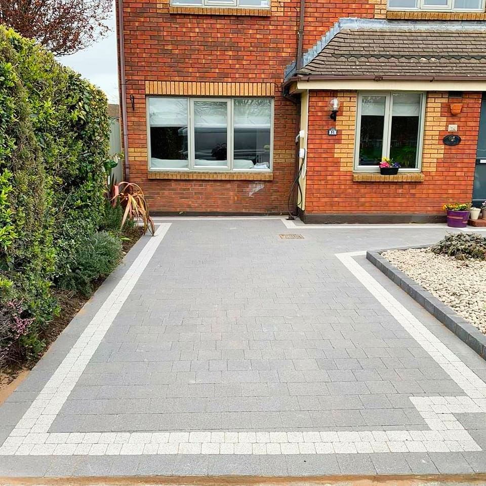 A brick house with a paved driveway bordered by a white line.