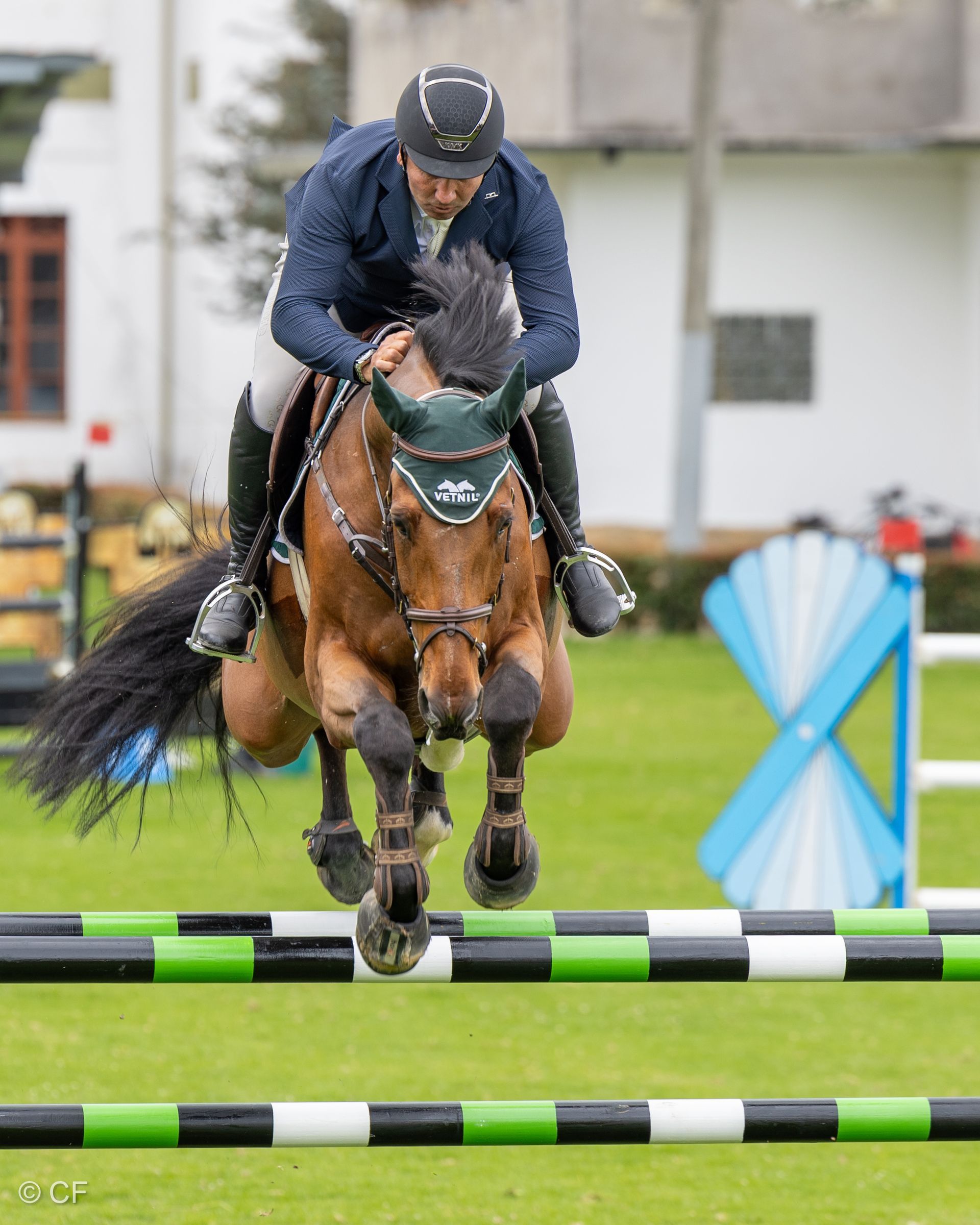 A man is riding a horse over a jump.