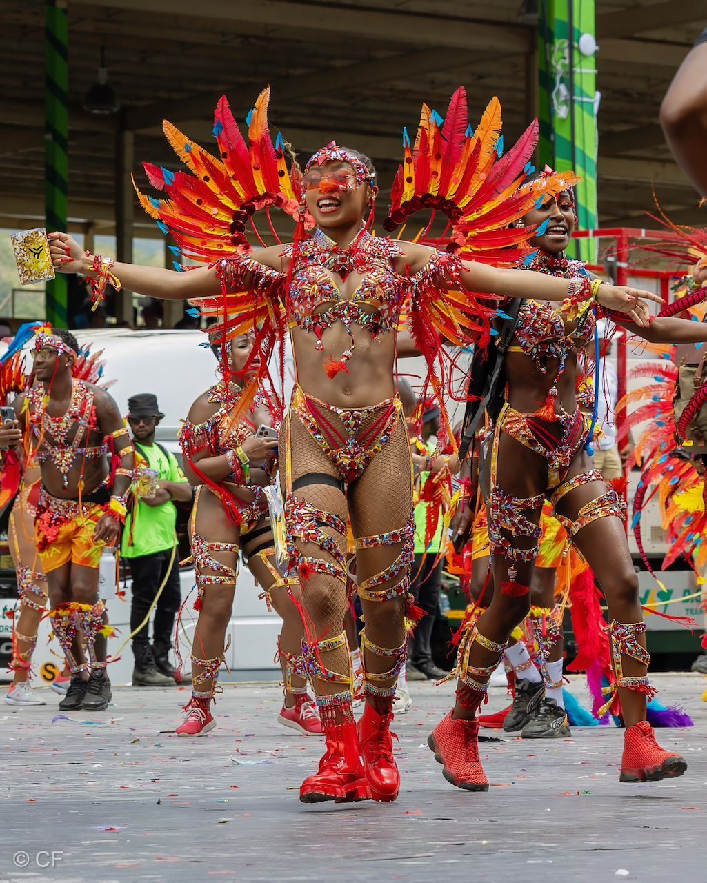 a woman 5 in a colorful costume is dancing in a parade .