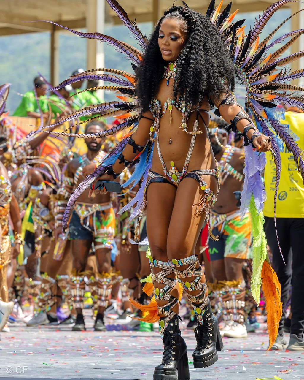 a woman 4 in a colorful costume is walking in a parade .
