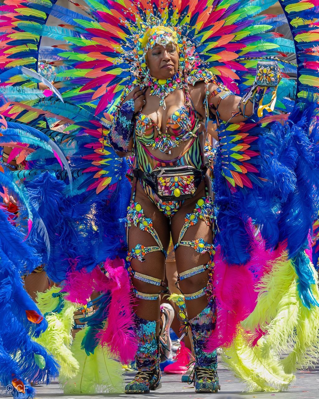 a woman 2 in a colorful costume is dancing in a parade .