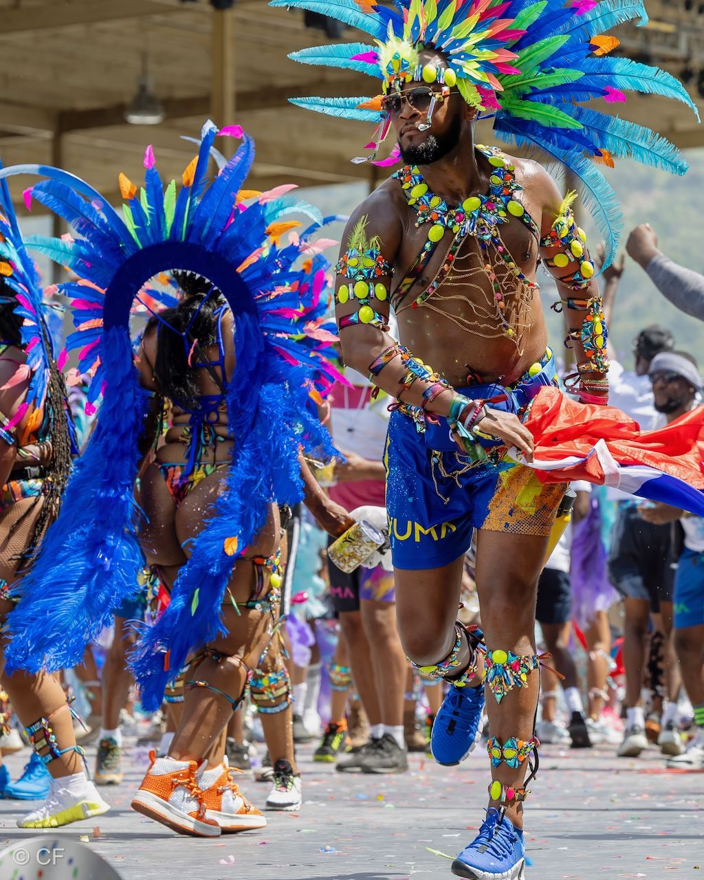 a woman 1 in a colorful costume is dancing in a parade .