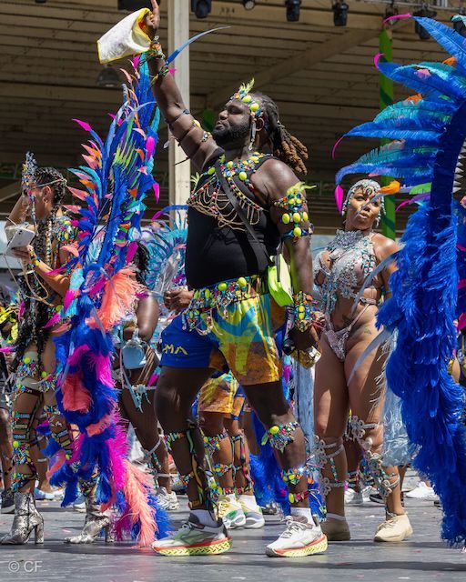 A group of people in colorful costumes are dancing in a parade.