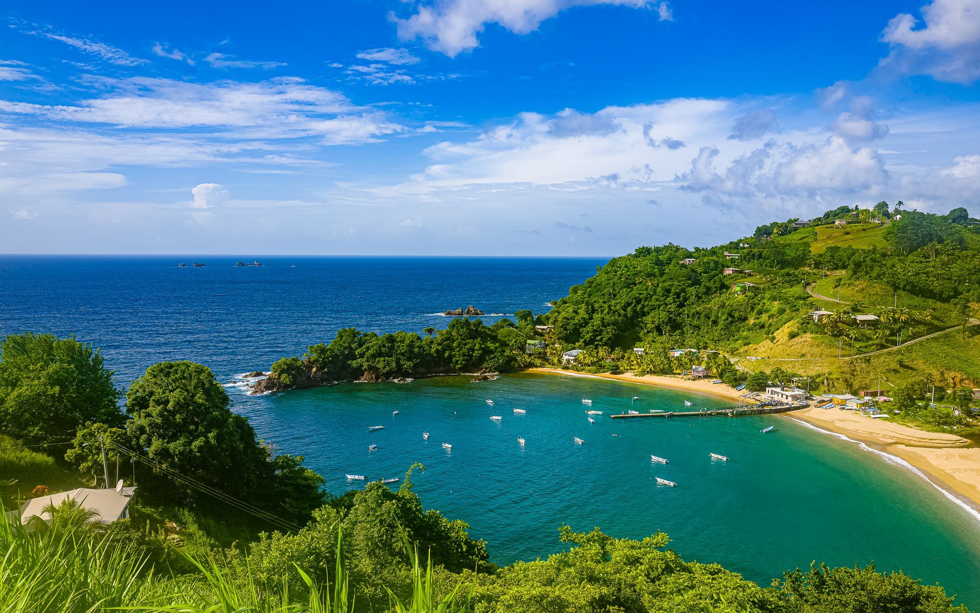 An aerial view of a tropical beach with boats in the water.