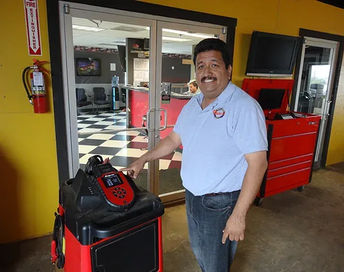A man in a blue shirt is standing in front of a fire extinguisher