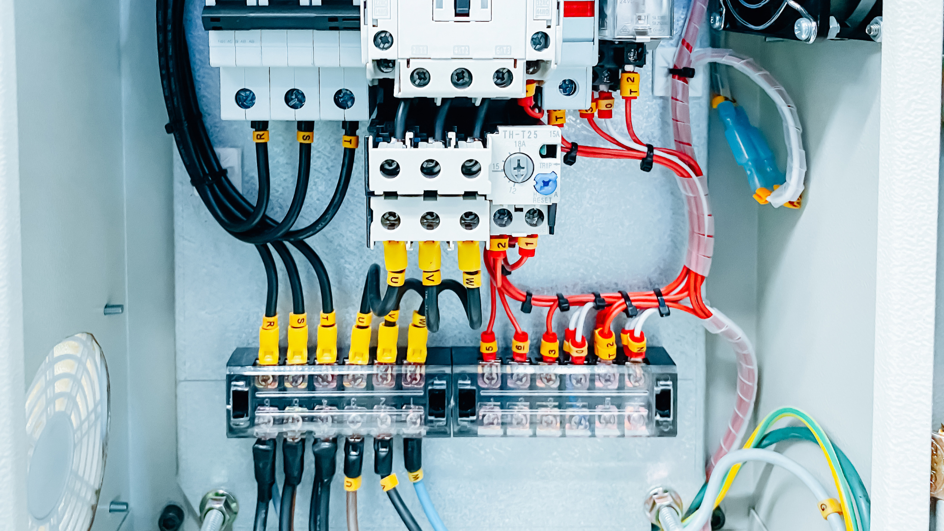Electrical control panel with circuit breakers, wiring, and terminal blocks inside a cabinet
