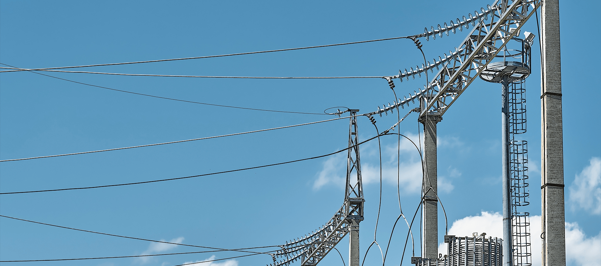 Power lines and utility poles against a blue sky