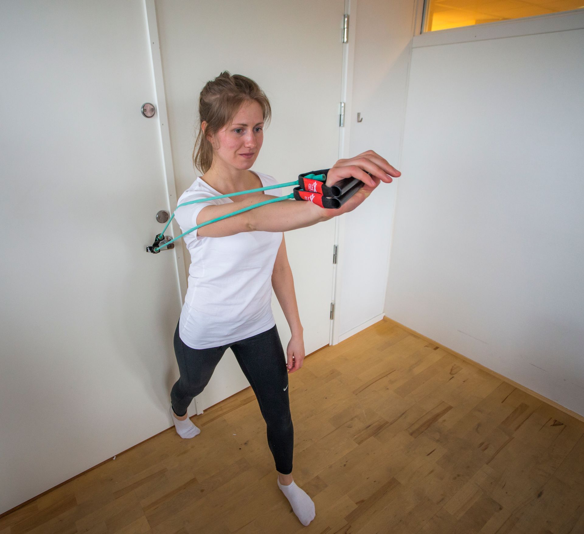 En kvinne bruker et motstandsbånd på armen.