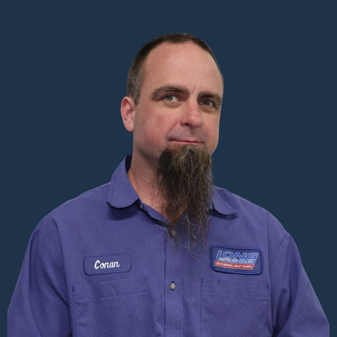 Man in a blue work shirt against a dark blue background, facing slightly left with a neutral expression