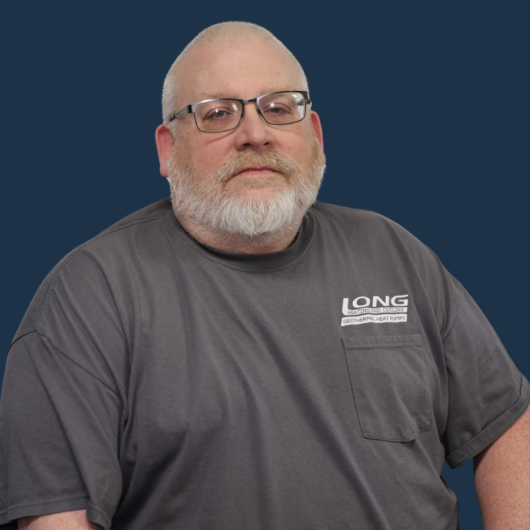 Portrait of a bald man with glasses and a gray beard wearing a gray T-shirt against a blue background