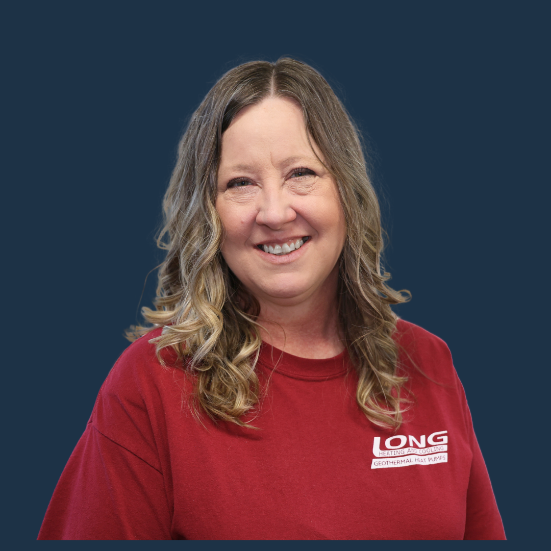 Smiling person in a red LONG shirt against a dark blue background.