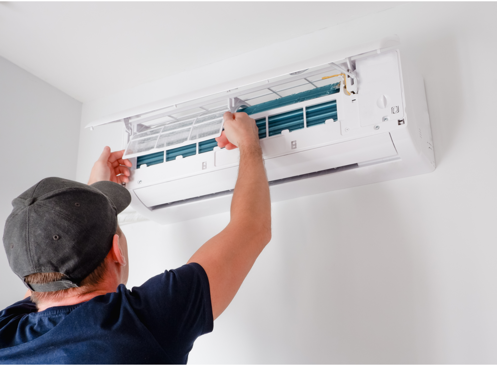 Technician cleaning an open wall-mounted air conditioner with a cloth