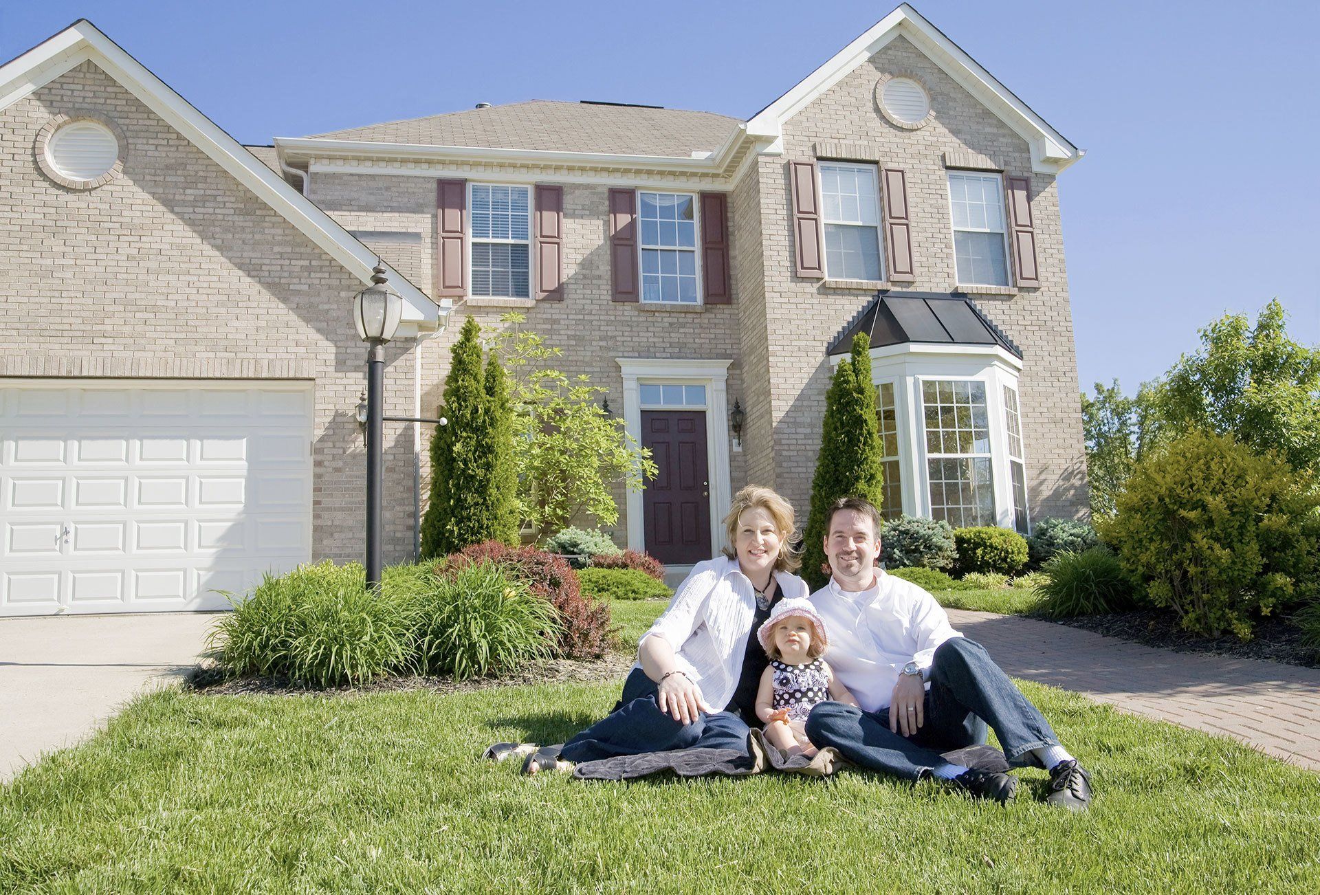 Family sitting in front of a house