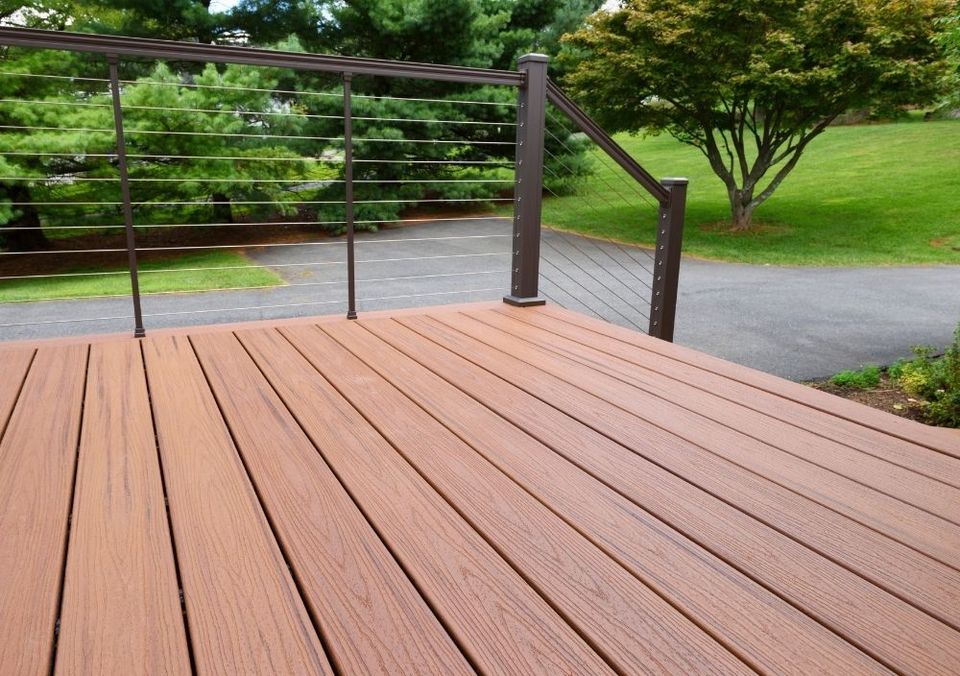 Timber-effect composite decking with a cable balustrade overlooking a lawn