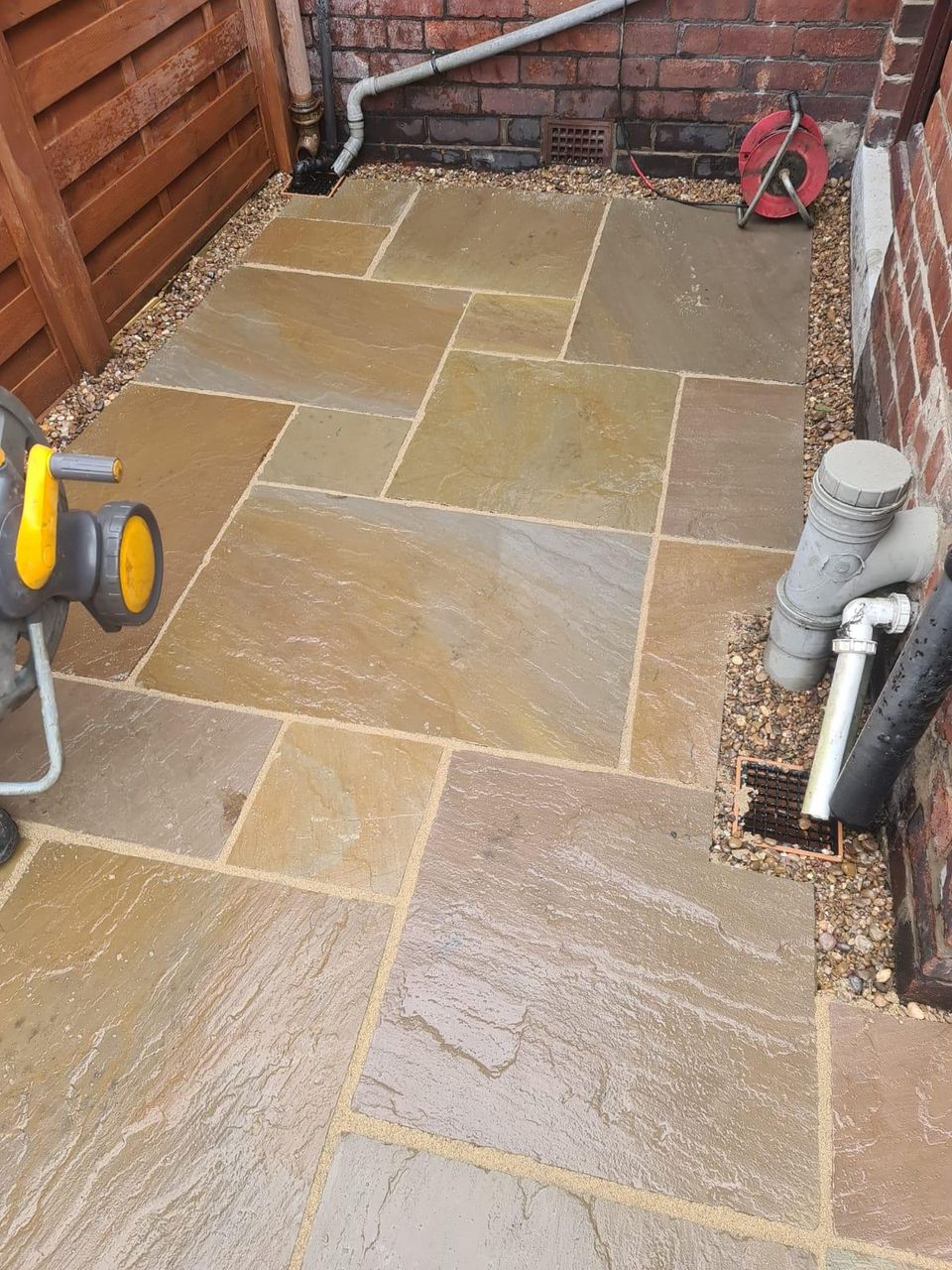 Indian sandstone paving laid down the side of a house in Cardiff