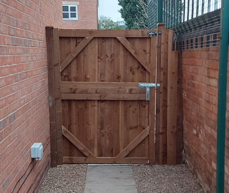 Wide wooden side gate seen from inside the garden