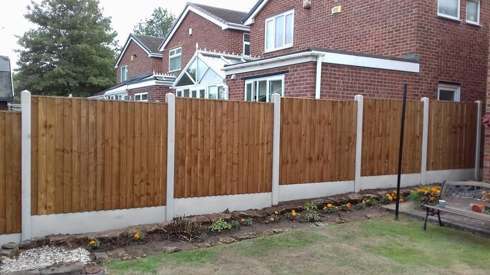 Run of featheredge fence panels with concrete posts along a back garden