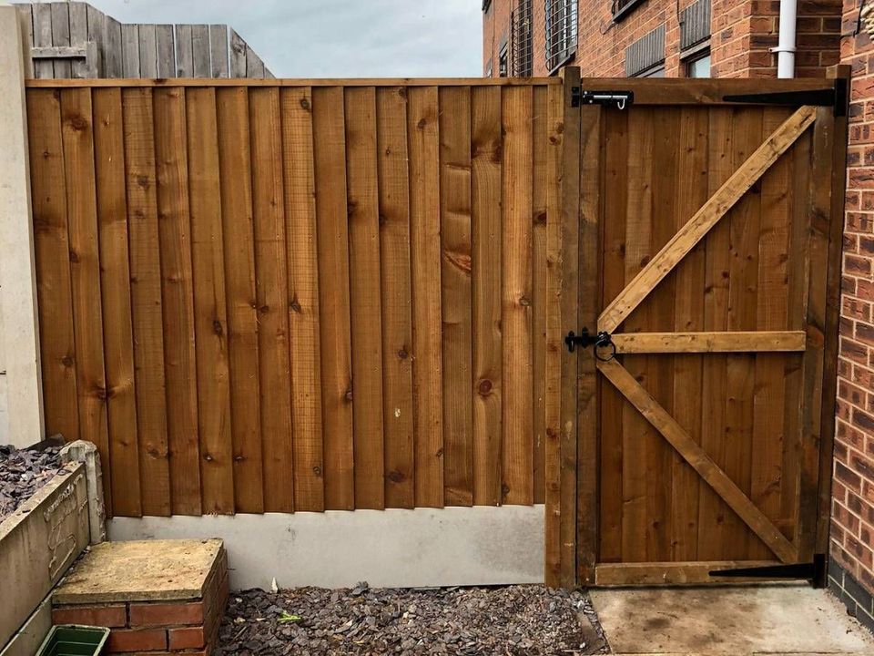 Ledged and braced featheredge side gate hung beside a new featheredge fence panel