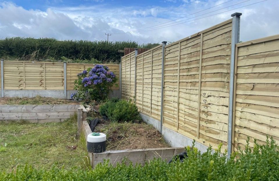 New lap panels between concrete posts on concrete gravel boards along a Caerphilly garden